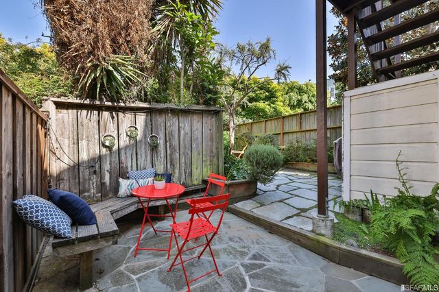 an outdoor sitting area with furniture and wooden fence