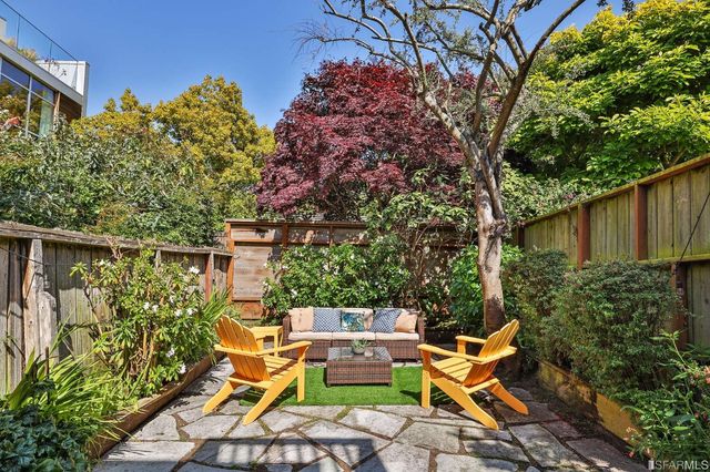 a view of a chairs and table in the back yard of the house