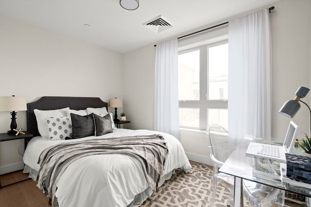 a bedroom with a bed a table and a window