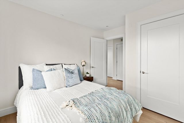 a bedroom with a bed and wooden floor