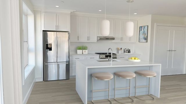 a kitchen with stainless steel appliances granite countertop a refrigerator and a stove top oven