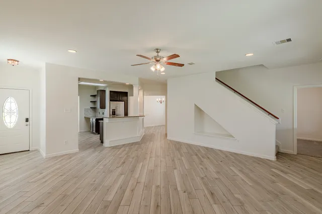 a living room with furniture and a wooden floor