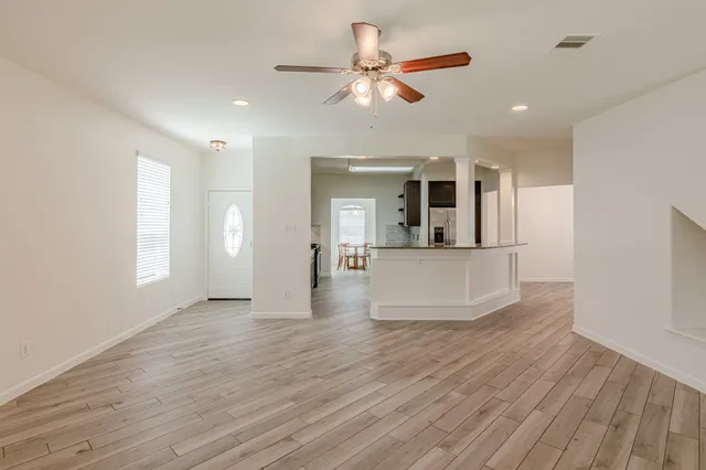a view of a living room a kitchen and a wooden floor