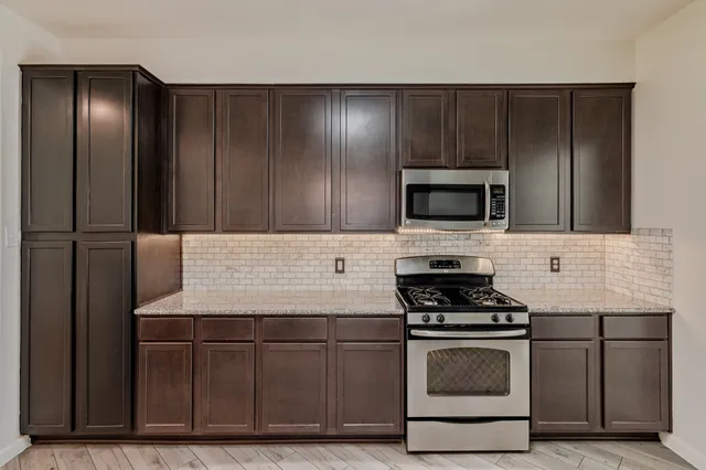 a kitchen with wooden cabinets and stainless steel appliances