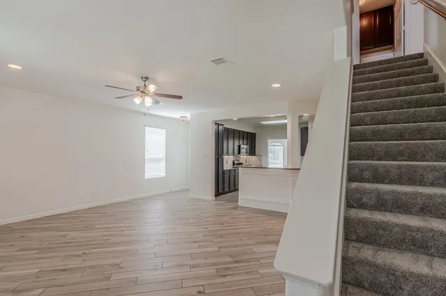 a view of a livingroom with wooden floor and staircase