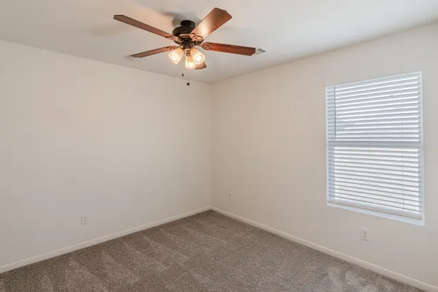 an empty room with chandelier fan