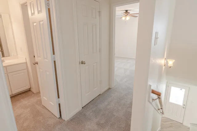 an empty room with a window and a fan