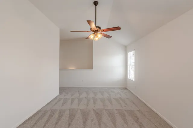 an empty room with windows and fan