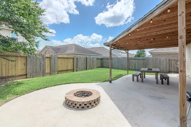 a view of a backyard with table and chairs under an umbrella