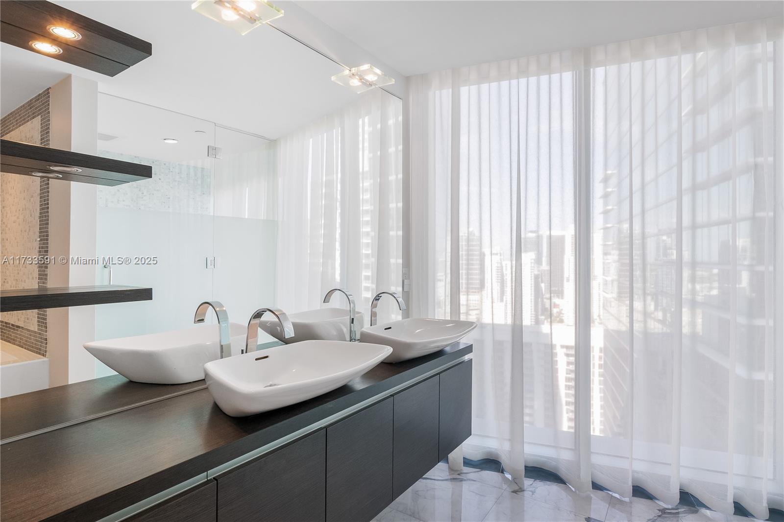 200 Biscayne Blvd Way, Unit 4101 Miami, FL 33131 - Photo 14 of 30 a bathroom with a double vanity sink and a large mirror