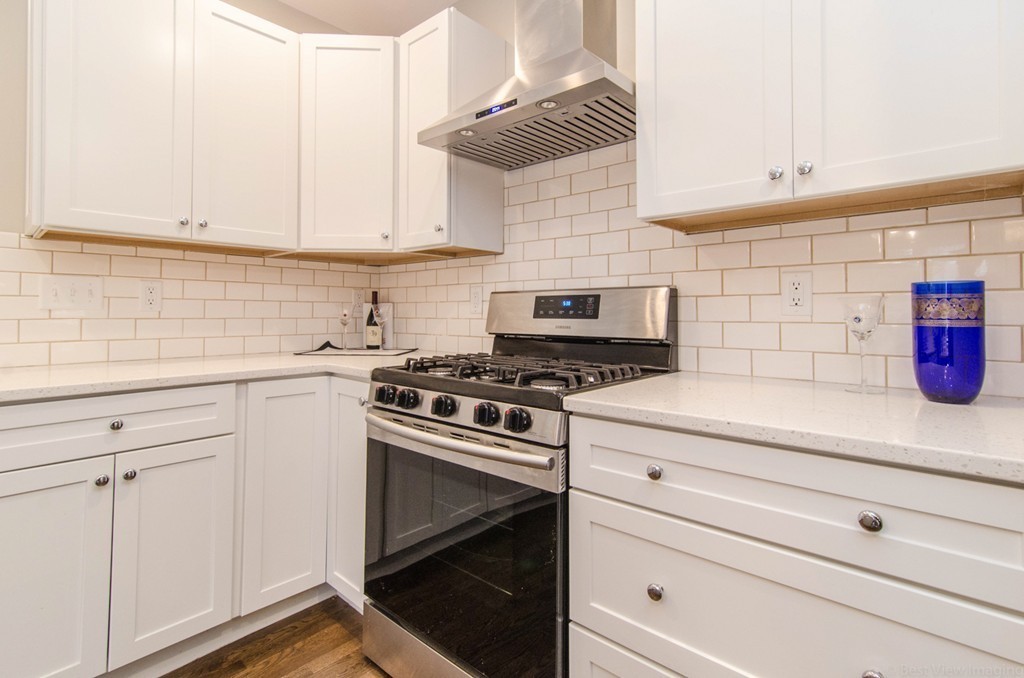 718 Main Street Acton, MA 01720 - Photo 27 of 28 a kitchen with white cabinets and white appliances