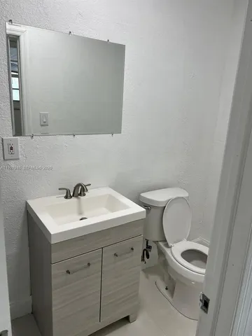 a bathroom with a toilet a sink and mirror