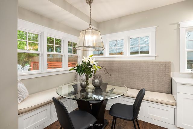 a dining room with furniture a large window and wooden floor