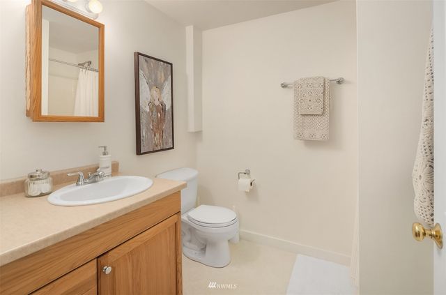 a bathroom with a toilet sink vanity and mirror