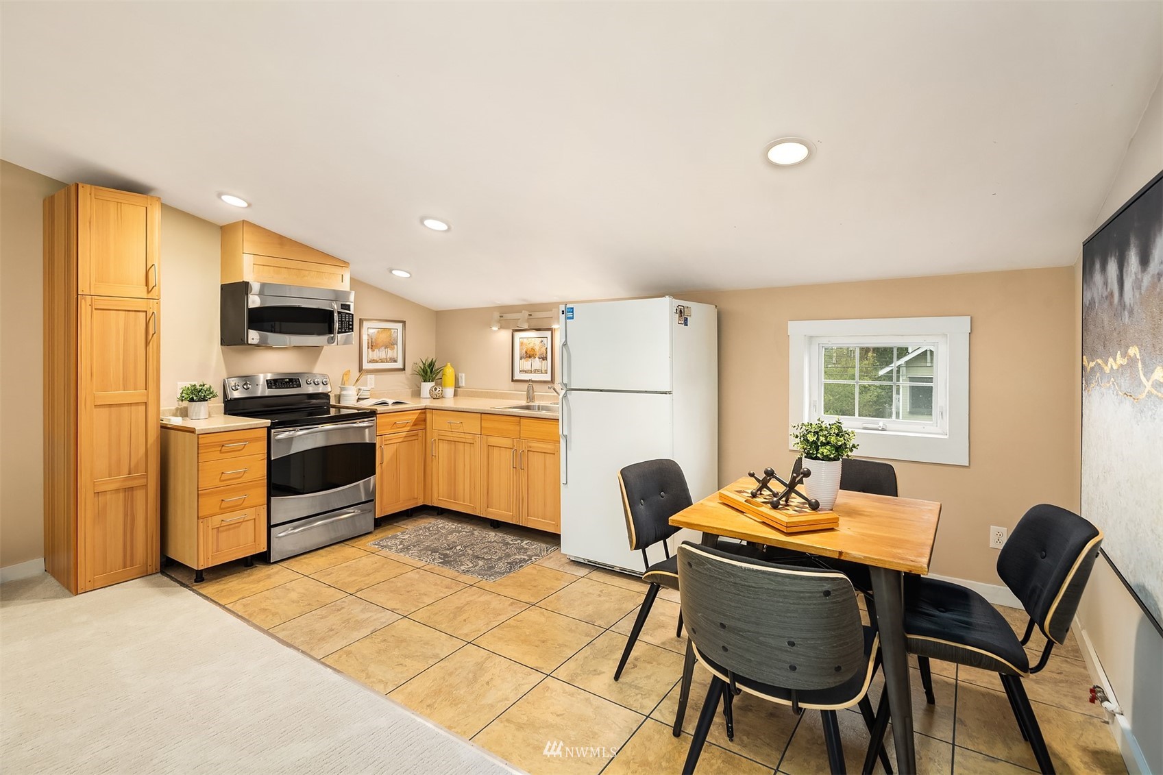 6065 5th Avenue Northeast Seattle, WA 98115 - Photo 32 of 40 a kitchen with a refrigerator a stove a sink dishwasher with a dining table and chair