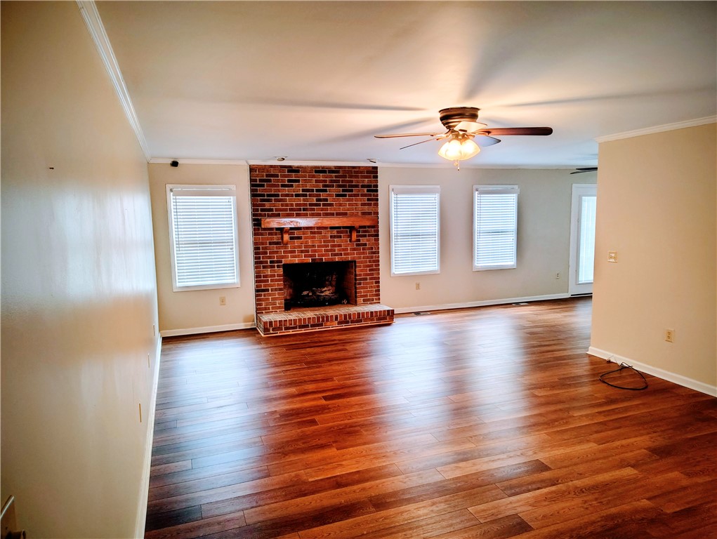 1809 Busby Road Anderson, SC 29626 - Photo 24 of 43 This inviting living area boasts rich wood flooring and a classic brick fireplace, creating a warm ambiance.