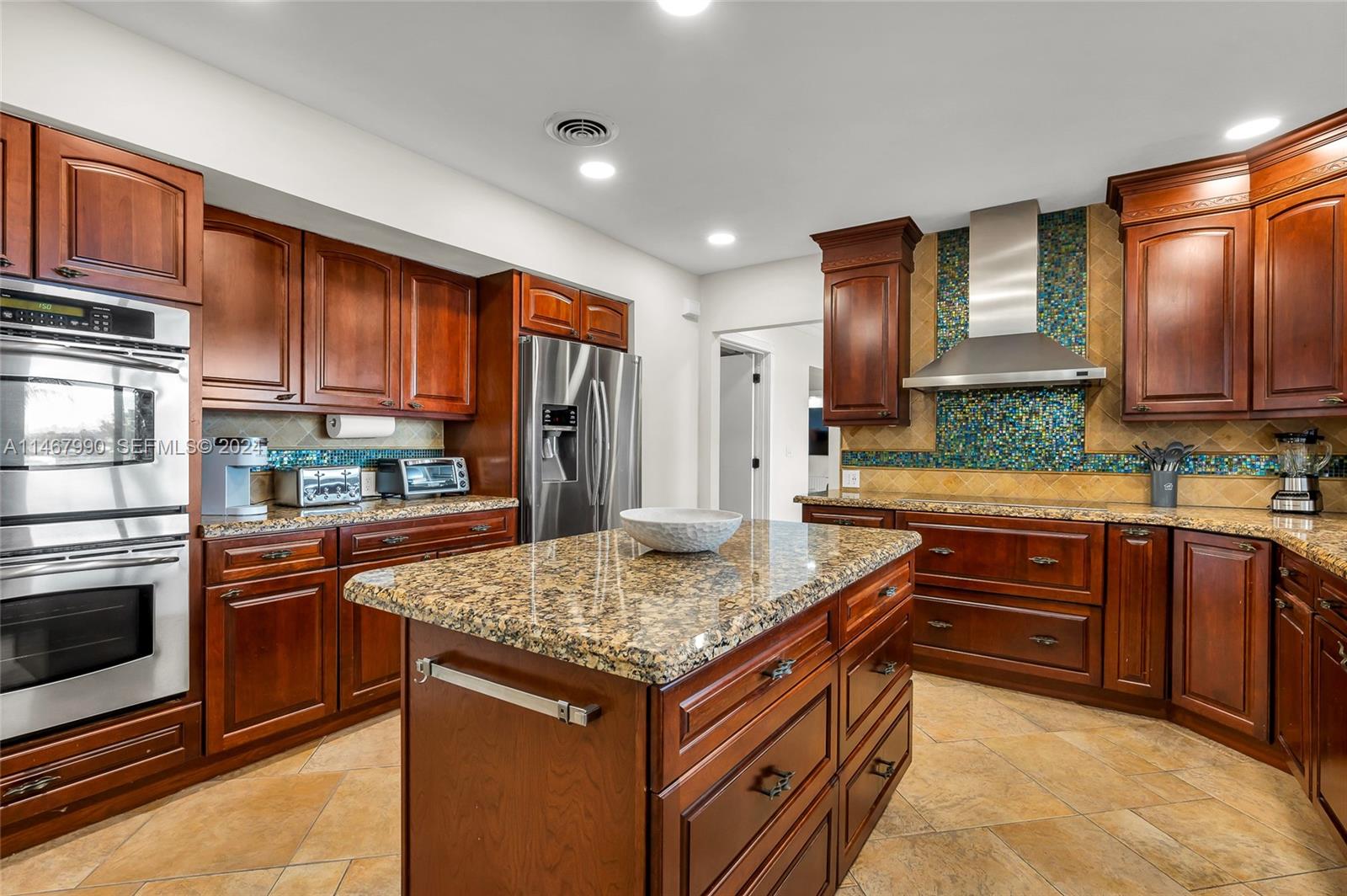 2500 Northeast 199th Street Miami, FL 33180 - Photo 15 of 72 a kitchen with stainless steel appliances granite countertop wooden cabinets and a stove top oven