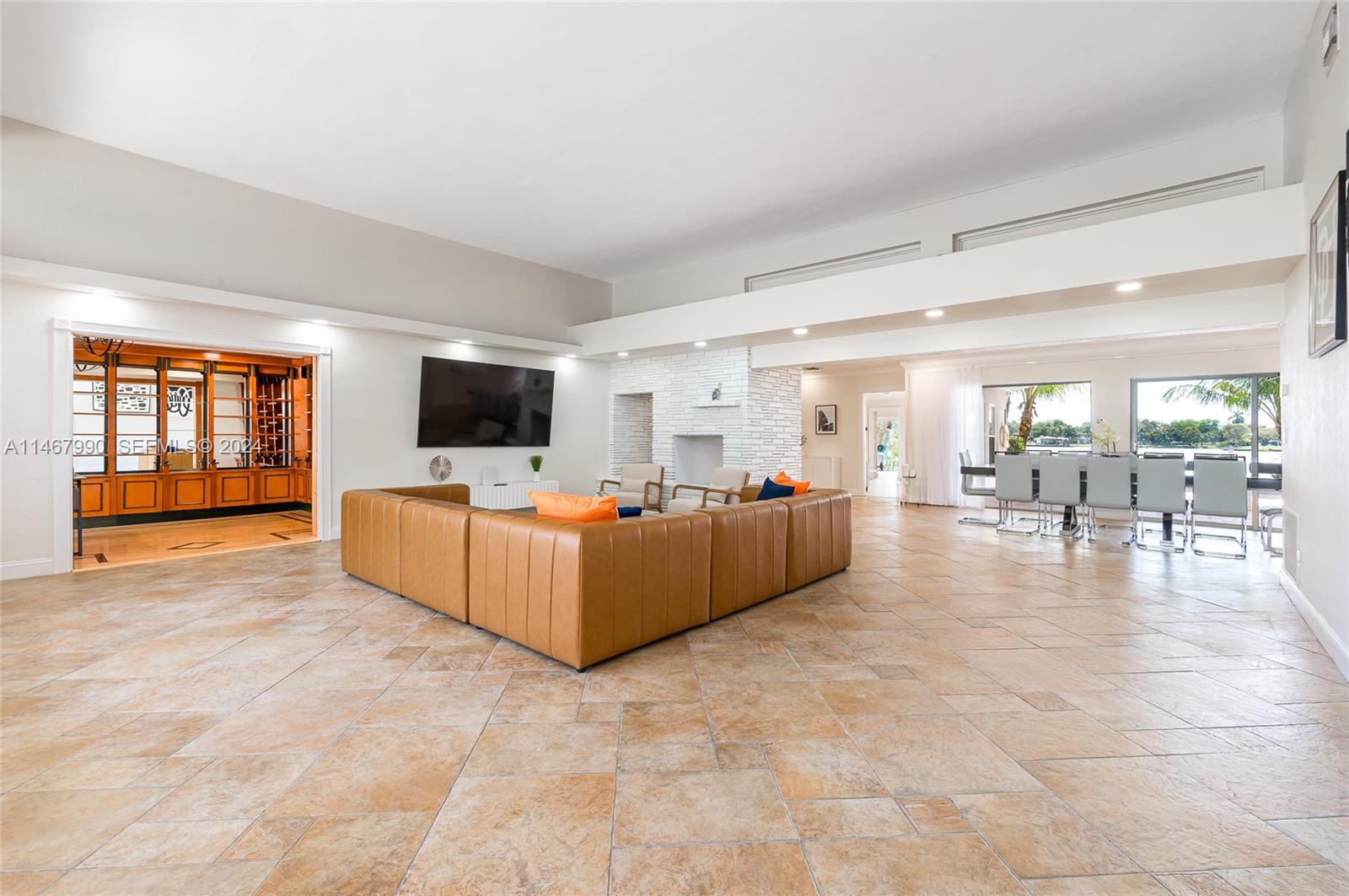 2500 Northeast 199th Street Miami, FL 33180 - Photo 5 of 72 a living room with couches and a flat screen tv with kitchen view