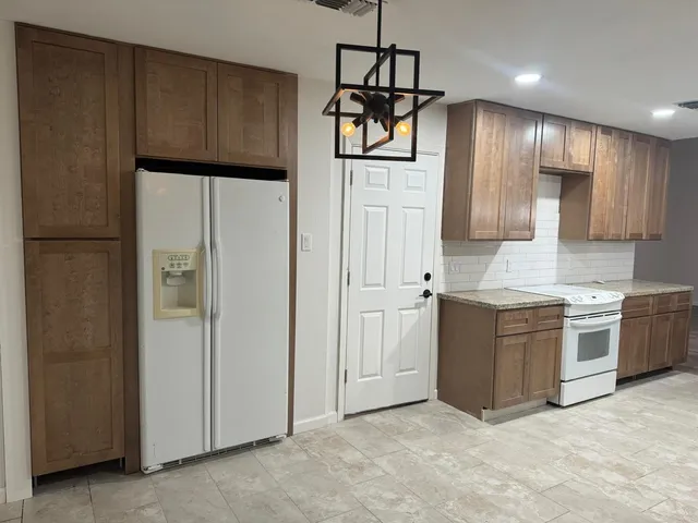 a kitchen with stainless steel appliances granite countertop a refrigerator a sink and dishwasher