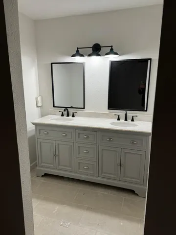 a bathroom with a double vanity sink and mirror