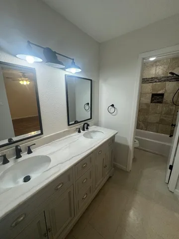 a bathroom with a double vanity sink and a mirror