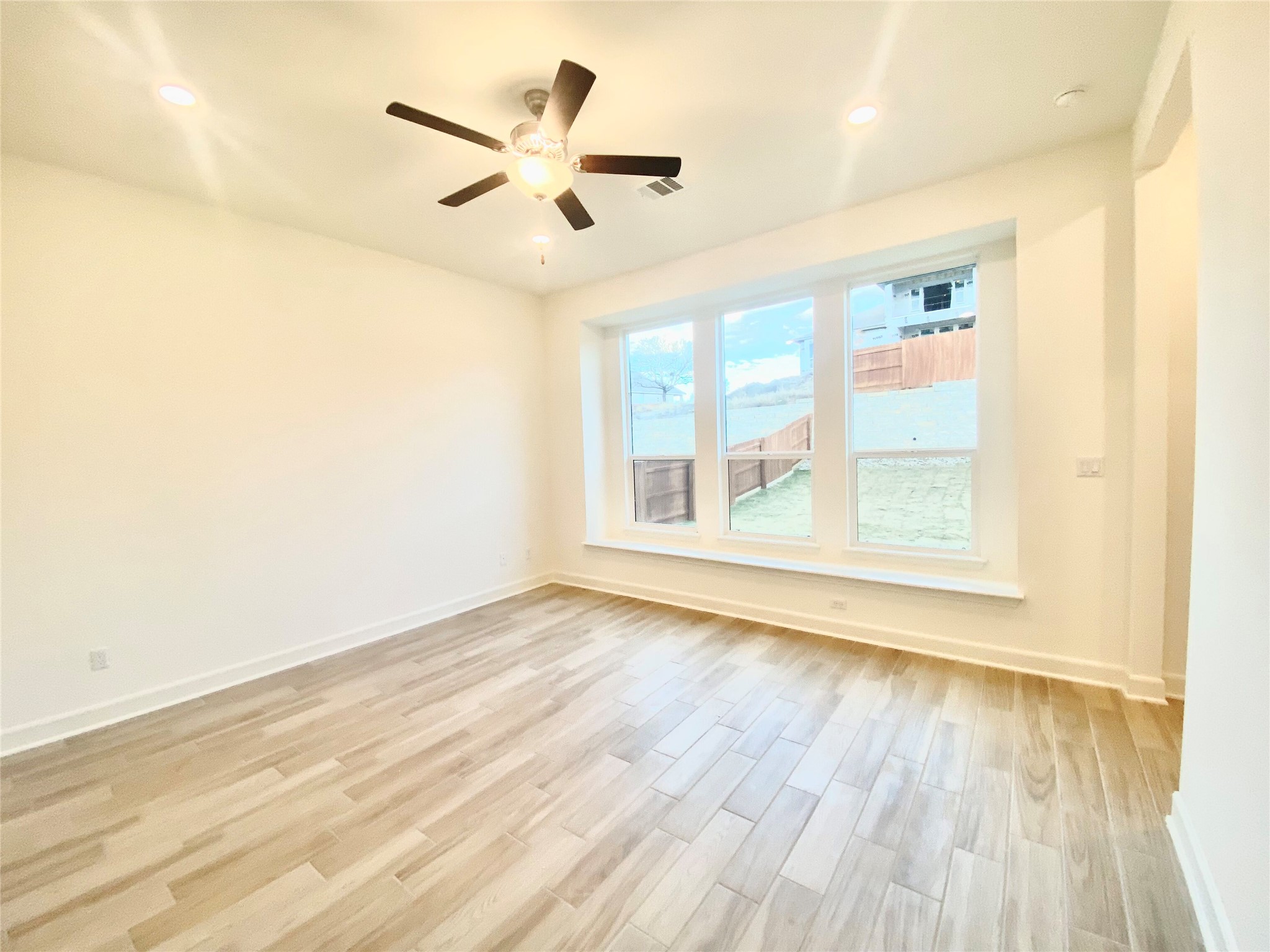 6009 Cimarron Ridge Lane Austin, TX 78738 - Photo 8 of 21 an empty room with wooden floor fan and windows