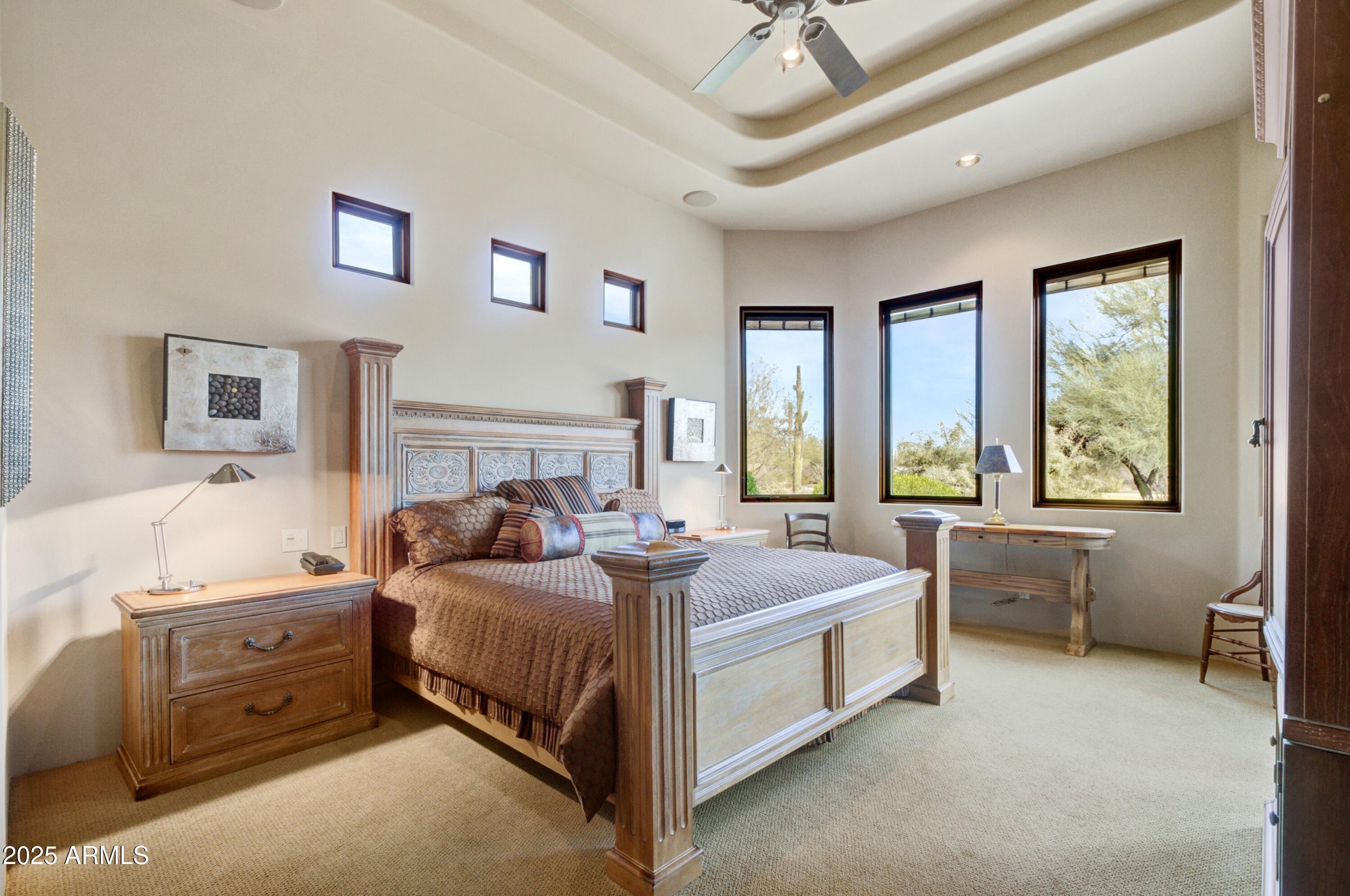 28013 Desierto Drive Rio Verde, AZ 85263 - Photo 12 of 33 a bedroom with a bed and a chandelier
