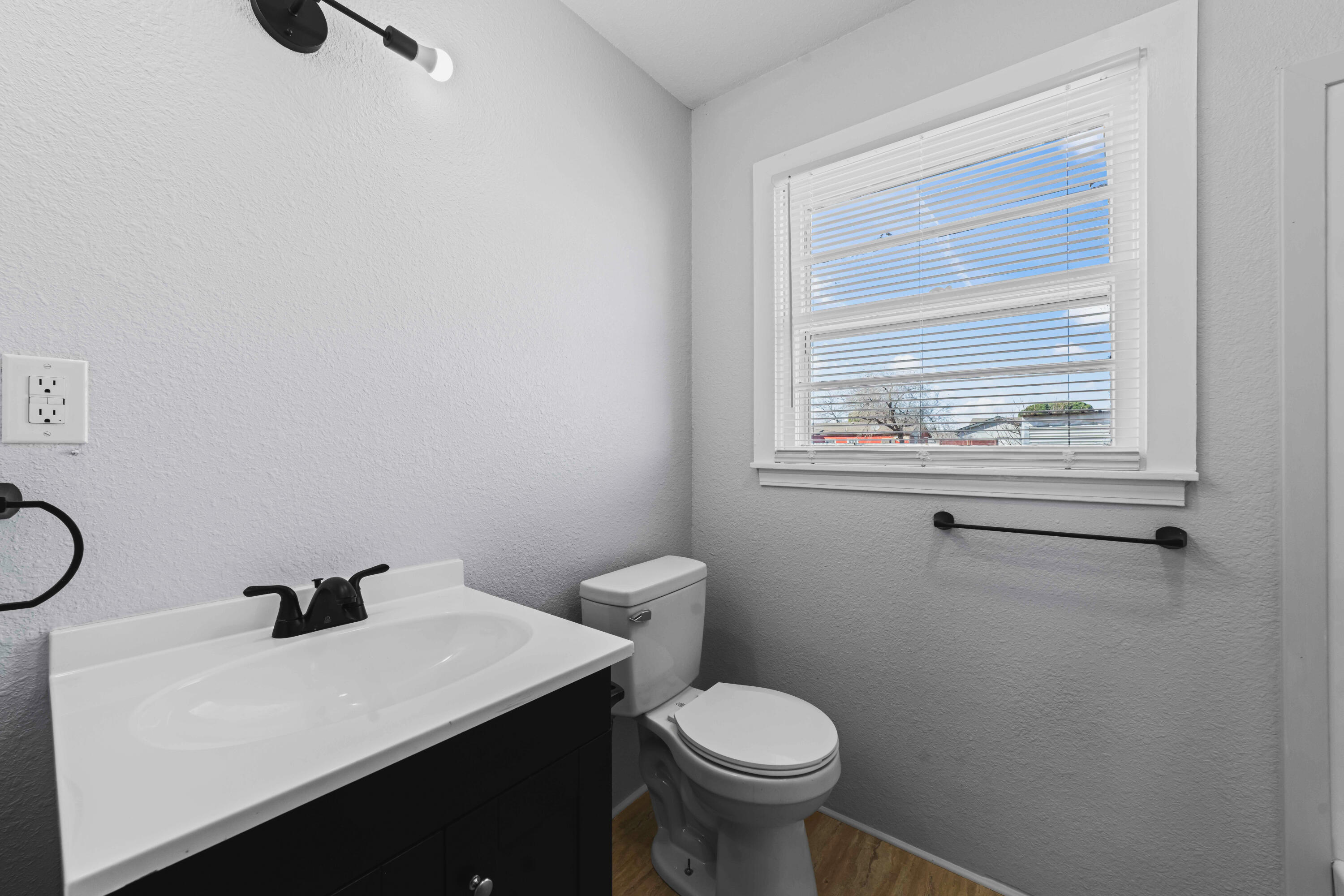 3017 East 3rd Street Lubbock, TX 79403 - Photo 12 of 15 a bathroom with a sink a toilet and a window
