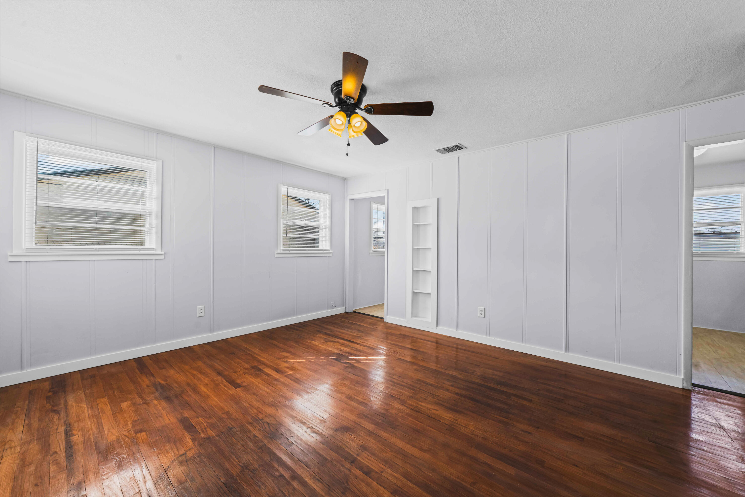 3017 East 3rd Street Lubbock, TX 79403 - Photo 3 of 15 a view of empty room with wooden floor and fan