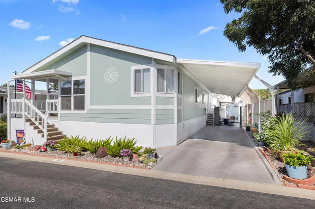 a front view of a house with a yard and potted plants