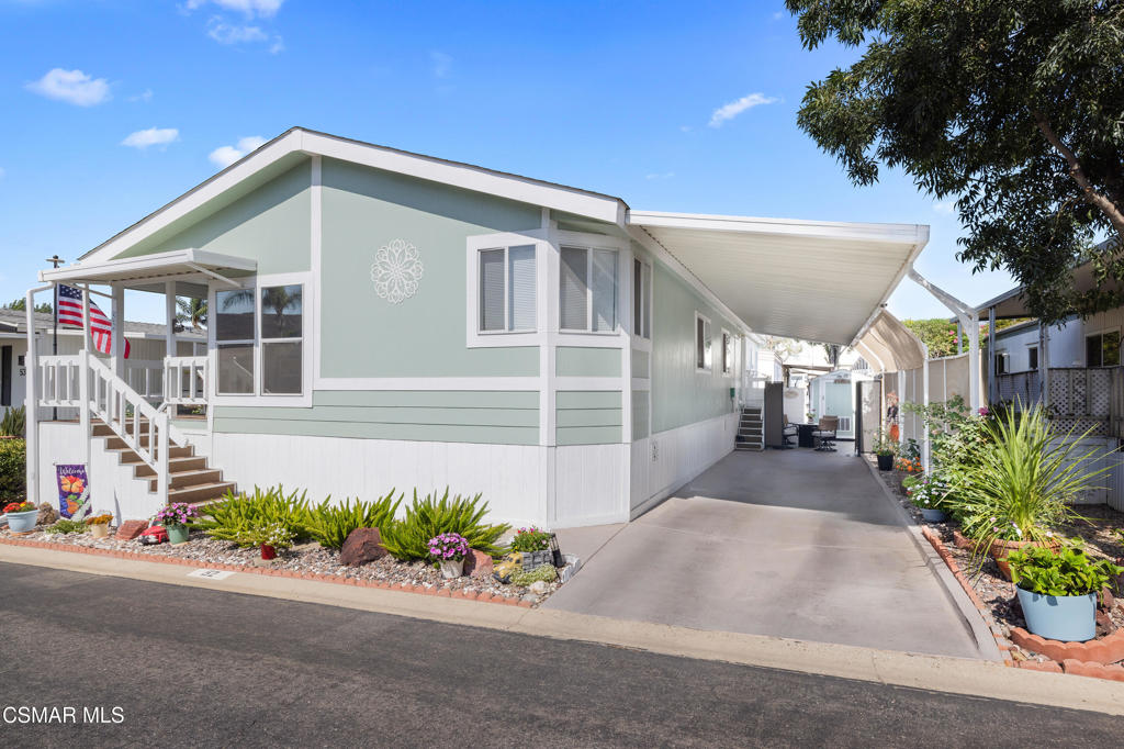 a front view of a house with a yard and potted plants