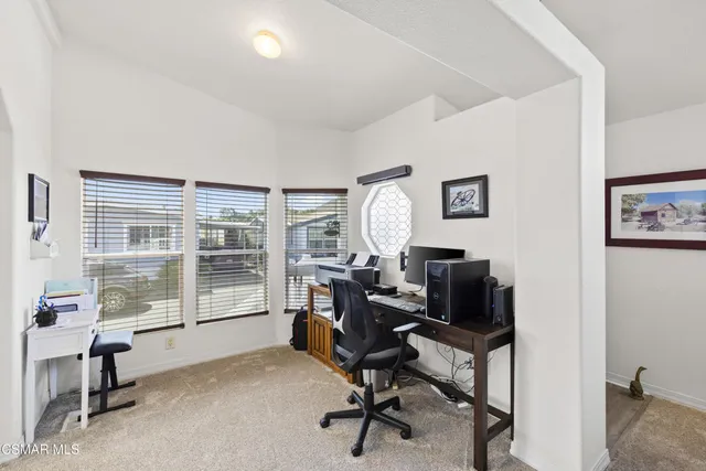 a view of a workspace with furniture and a window