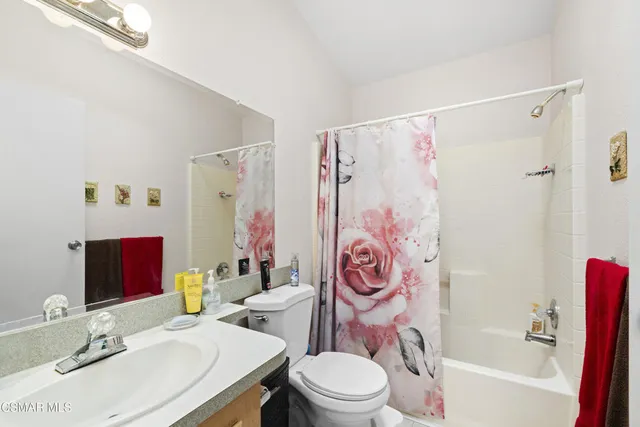 a bathroom with a sink a toilet and shower curtain