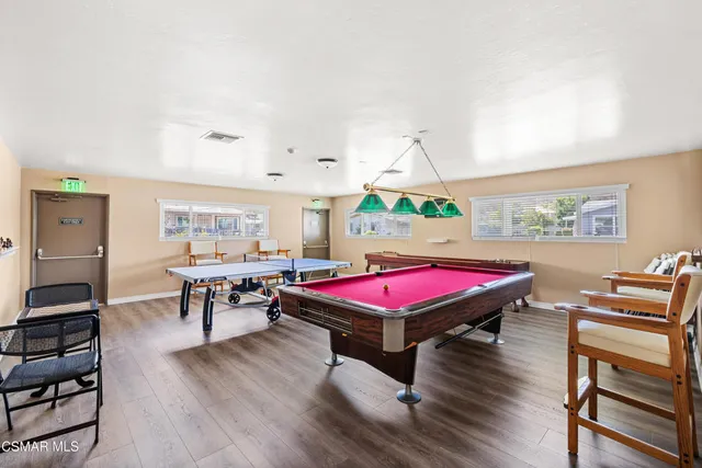a room with furniture pool table and wooden floor