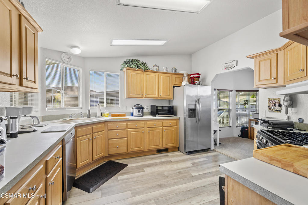 195 Tierra Rejada Road, Unit 52 Simi Valley, CA 93065 - Photo 9 of 34 a kitchen with stainless steel appliances granite countertop a refrigerator stove top oven and sink