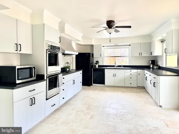 a kitchen with granite countertop a white cabinets and appliances