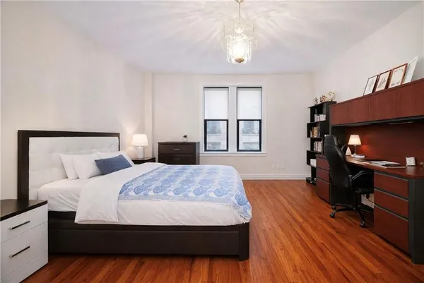 a bedroom with a bed and a flat tv screen on dresser