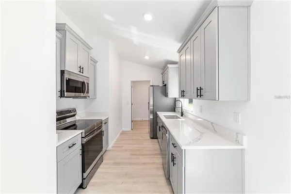 a kitchen with stainless steel appliances granite countertop a sink stove and refrigerator
