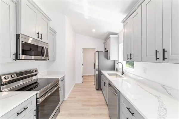 a kitchen with stainless steel appliances granite countertop a sink and a stove