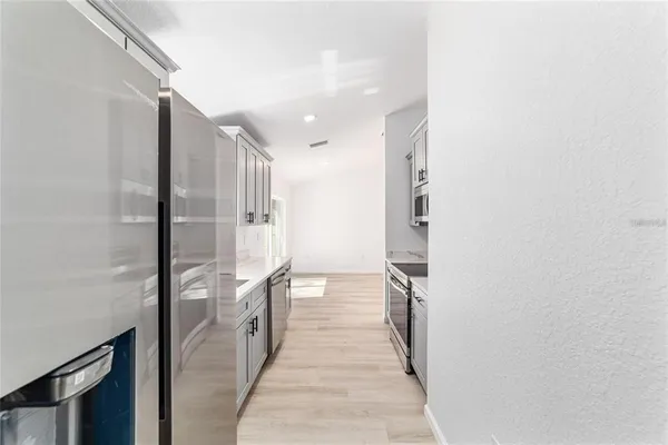 a hallway with white cabinets and wooden floor