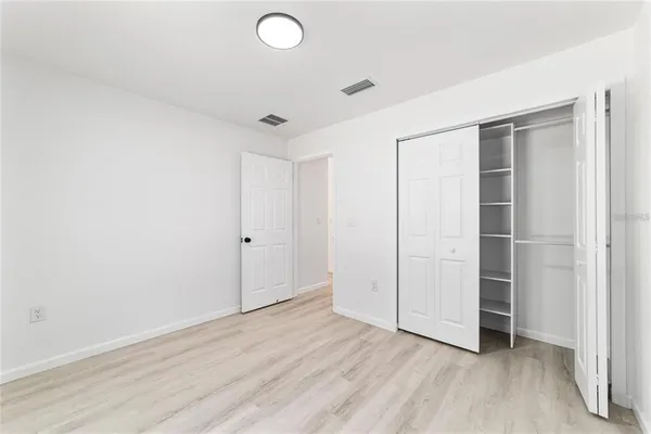 an empty room with wooden floor and closet
