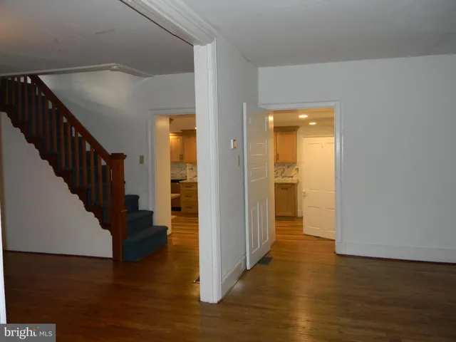 a view of a hallway with wooden floor and staircase