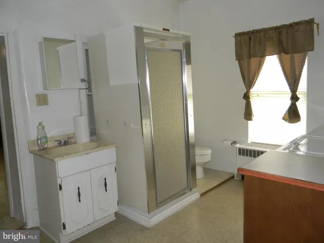 a bathroom with a granite countertop sink a toilet and a mirror