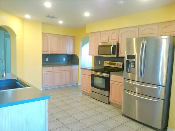 a kitchen with stainless steel appliances a refrigerator sink and microwave