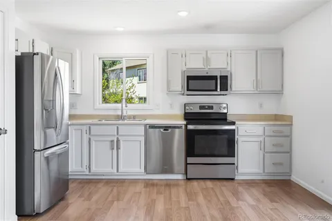 a kitchen with granite countertop a refrigerator stove and microwave