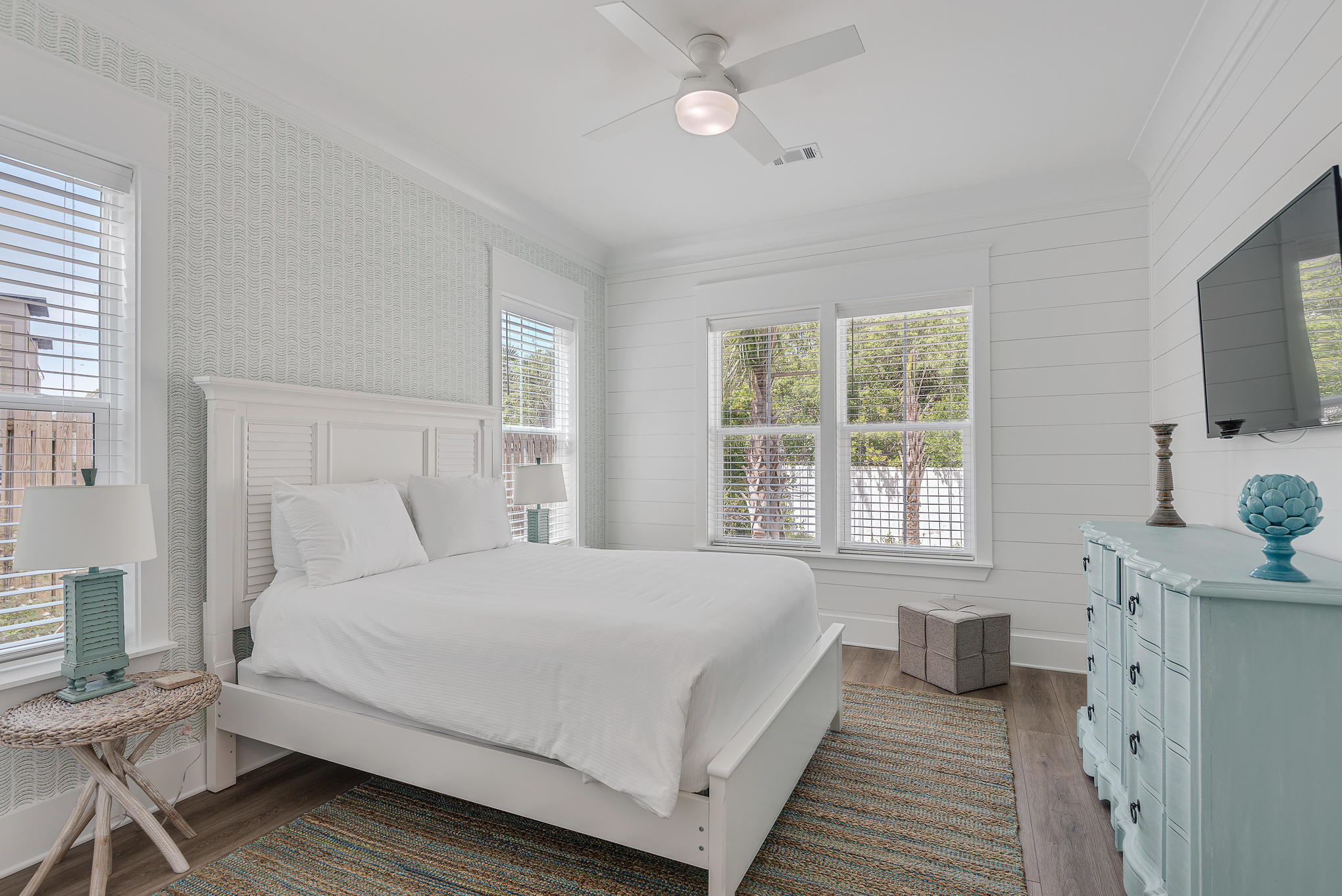 8427 East County Highway Seacrest, FL 32461 - Photo 15 of 74 a bedroom with a large bed and a flat tv screen on dresser