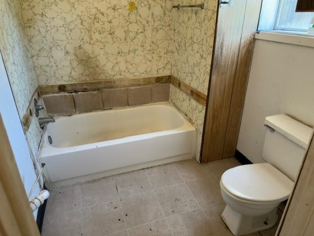 611 South Ruddell Street Denton, TX 76205 - Photo 9 of 18 a white bath tub sitting next to a white toilet