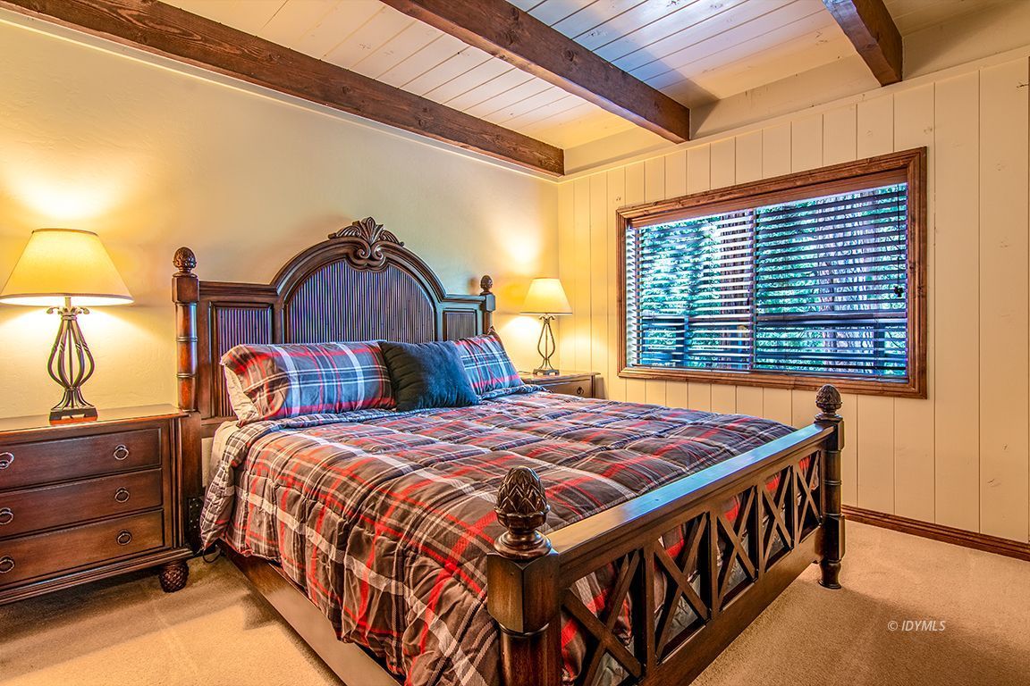 24750 Upper Rim Rock Road Idyllwild, CA 92549 - Photo 29 of 58 a bedroom with a bed and a lamp on dresser