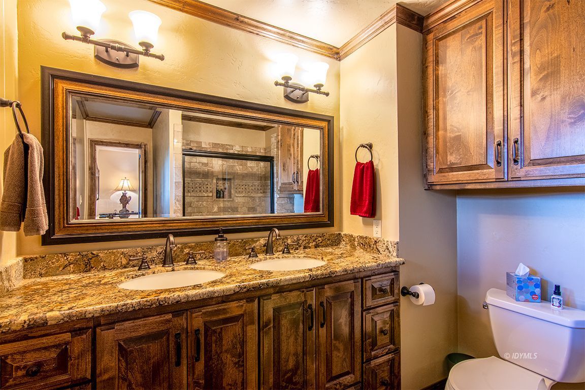 24750 Upper Rim Rock Road Idyllwild, CA 92549 - Photo 34 of 58 a bathroom with a granite countertop sink a toilet and a mirror