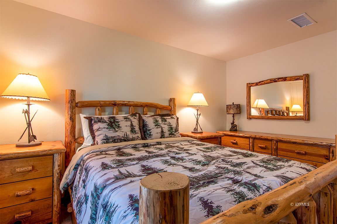 24750 Upper Rim Rock Road Idyllwild, CA 92549 - Photo 36 of 58 a bedroom with a bed and a lamp on dresser